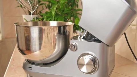 Adding ingredients to metal bowl of planetary mixer and mixing. Preparation of Stock Footage 244804334