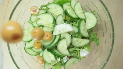Adding ingredients to a salad. Olives, olives, fresh cucumbers. Healthy food Stock-Footage 168897374