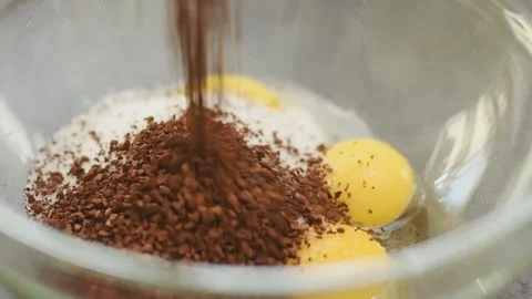 Adding instant coffee to egg yolks and sugar in the glass bowl. Stock Footage 159908924