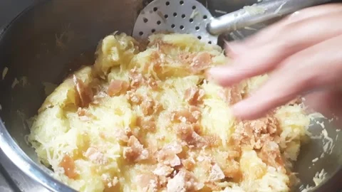 Adding Jaggery to Grated Raw Mango for Traditional Mango Preserve Preparation Video stock 335691143