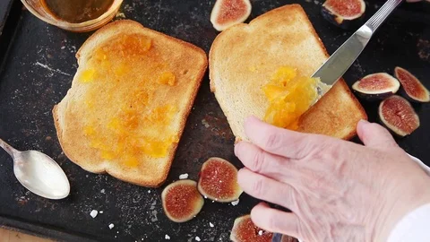 Adding jam and fresh figs to toast Stock Footage 95198748