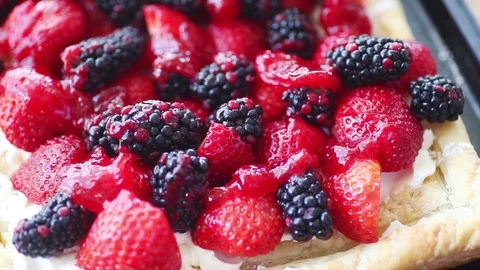 Adding jam glaze to berry tart 스톡 동영상 98549202