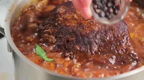 Adding juniper berries to braised beef Stock Footage 24664022