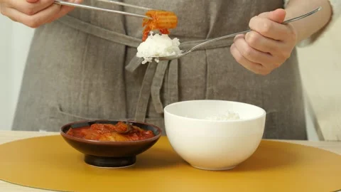 Adding Kimchi to Steamed Rice with Chopsticks 動画素材 334705236