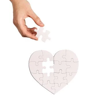 Adding last puzzle piece to complete jigsaw, love heart Stock Photos