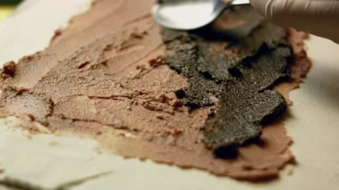 Adding a layer of mushroom pate over the sheet of puffy pastry Stock Footage 329356855