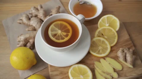 Adding lemon to cup of ginger tea. Alternative medicine herbal tea Stock Footage 147964875