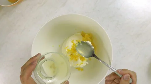 Adding lemon juice into cream cheese with lemon rind Stock Footage 100232146