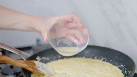 Adding lemon juice into a cream sauce in a frying pan in 4K. Stock Footage 138067158