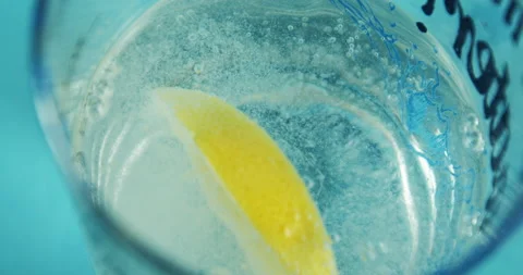 Adding lemon slice to the bubbling soda in the glass 動画素材 143281554