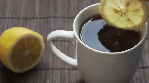 Adding lemon slice into the tea, slow motion Stock Footage 126835629