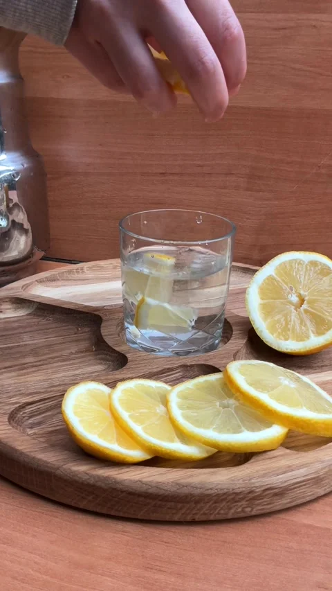 Adding Lemon Slices to Water in Glass, Healthy Hydration Concept Stock Footage 332216029