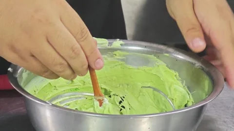 Adding liquid food coloring with a dropper into green cake cream. Stock Footage 344745087