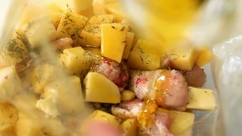 Adding liquid seasoning to meat and vegetables for roasting Stock-Footage 333834339