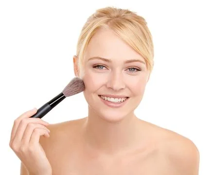 Adding a little color to my cheeks. A young woman applying blusher to her face Foto stock