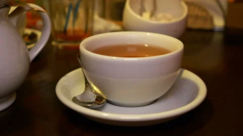 Adding lump sugar with pincers to black tea in cup Stock Footage 59205842