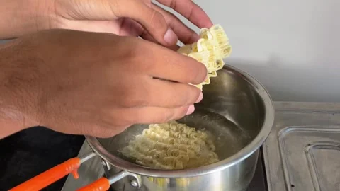 Adding Maggi Noodles into Boiling Water | Cooking Instant Noodles in Hot Pan Stock Footage 319115154