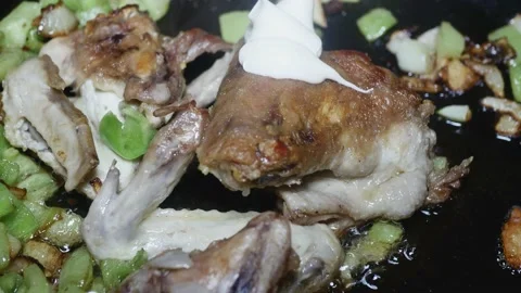 Adding mayonnaise to fried wings in a pan with vegetables Vídeos de archivo 225241484