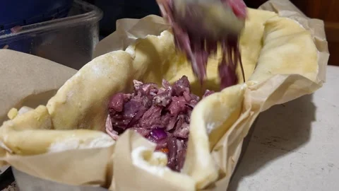 Adding meat filling to homemade pate en croute Stock Footage 345837762