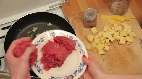 Adding meat to oignion and parsley Stock Footage 25621528