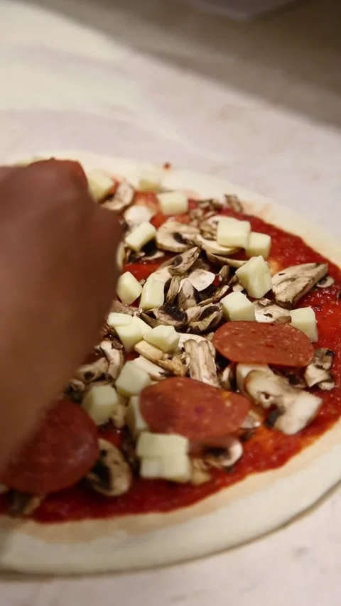 Adding meat slices to pizza by hand, perfect for food videos Stock Footage 310684843