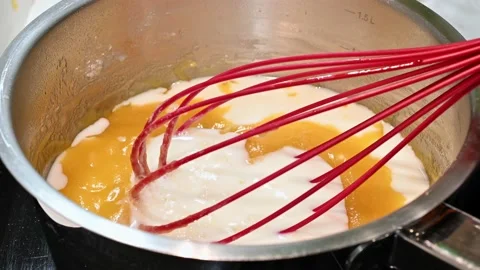 Adding milk to butter and flour, stirring well Stock Footage 219879130