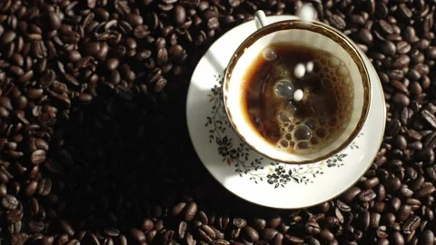 Adding milk to coffee in a beautiful white cup with an ornament. Video stock 237172912