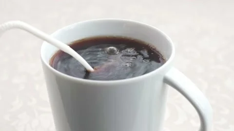 Adding milk to coffee in a mug Stock Footage 145418943