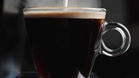 Adding milk to a cup of black coffee in slow motion Stock Footage 148141146