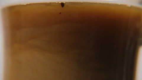 Adding milk into hot fresh coffee, macro view Stock Footage 321952450