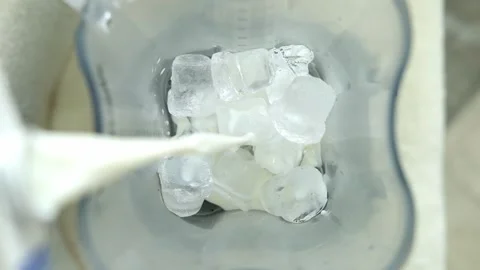 Adding milk to ice cubes in blender, making iced coffee beverage. Vídeos de archivo 307274923