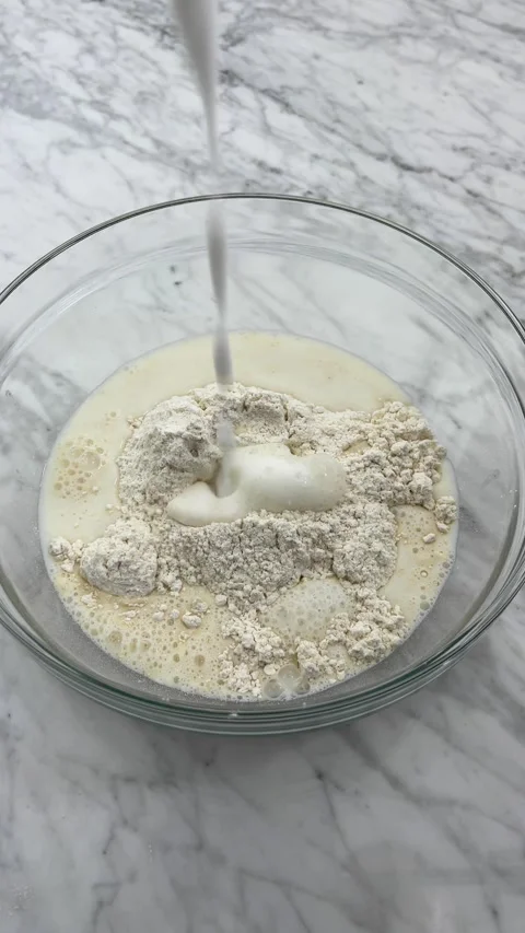 Adding milk to pancake flour Stock Footage 289455737