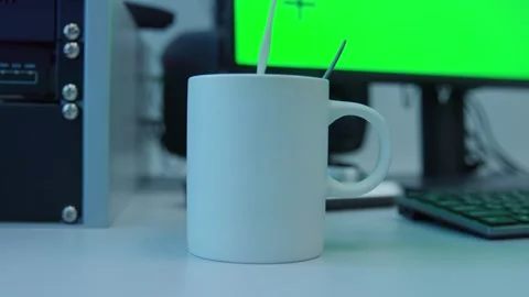Adding a milk to a white coffee cup in front of a green screen monitor Stock Footage 277475298