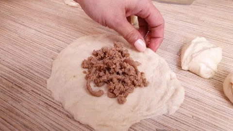 Adding minced meat to the dough. Making meat pies, home cooking, baking Stock Footage 319482979