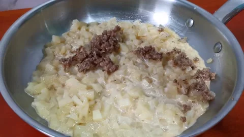 Adding Minced Meat on Top of Diced Potatoes in a Pan Stock Footage 162879937