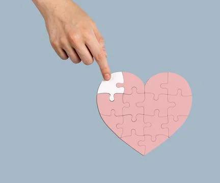 Adding the missing puzzle piece to heart-shaped jigsaw. Help, aid, donation.. Stock Photos
