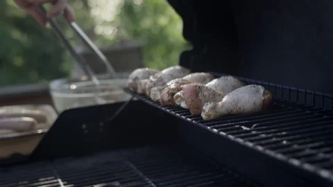 Adding more juicy marinated chicken to the grill 動画素材 153310436