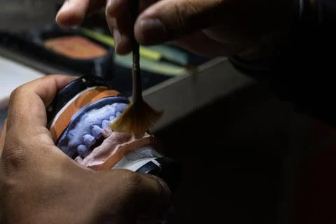 Adding more texture and finishing the prosthetic with a brush. Stock Photos
