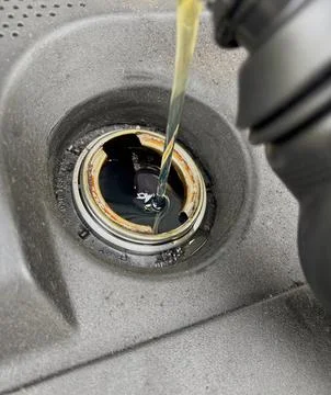 Adding motor oil to a car engine. Stock Photos