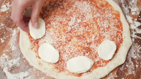 Adding mozzarella cheese on a pizza dough in 4K Stock Footage 137477782