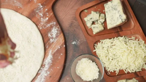 Adding mozzarella cheese on a pizza dough in 4K Stock Footage 137484150