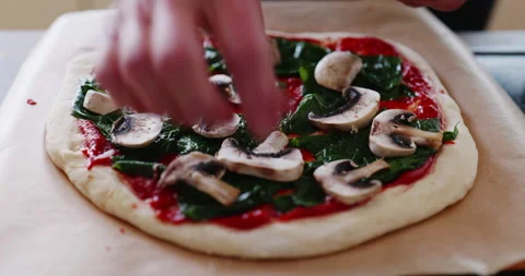 Adding mushrooms to home made pizza Stock Footage 241607260