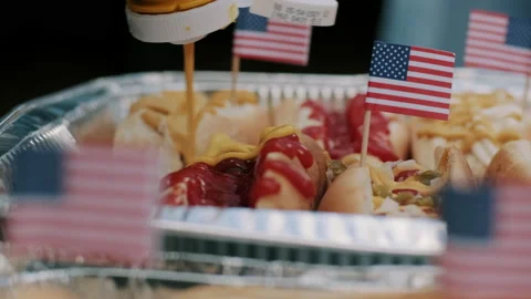 Adding Mustard to Hot Dogs for 4th of July Party Stock Footage 133416682