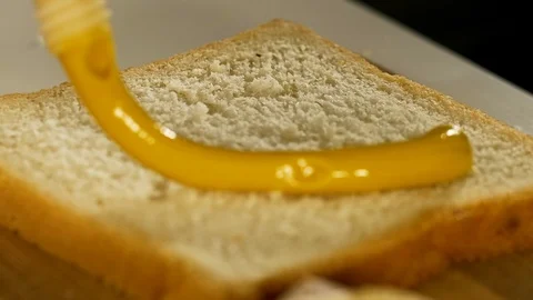 Adding mustard to toast close up Stockbeeldmateriaal 124961251
