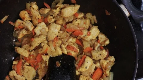 Adding noodles to chicken overhead Stock Footage 98361125