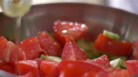 Adding oil and avocado to a cucumber on tomato salad Stock Footage 142190430