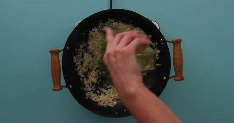Adding oil to green peppers, red peppers, and onions in a skillet Stock Footage 132198626