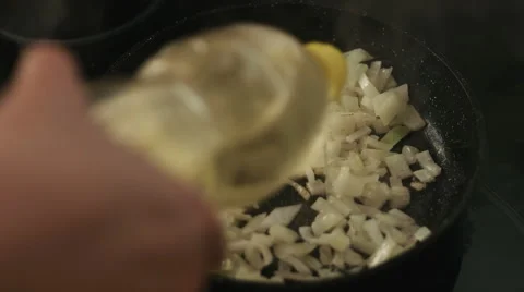 Adding oil to sliced onion to a frying pan Stock Footage 62475441