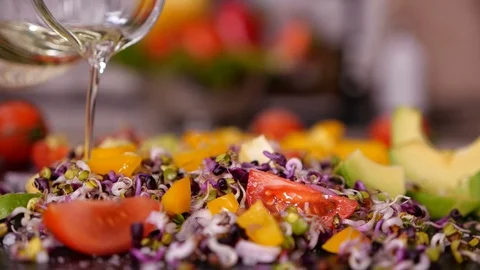 Adding oil to vegetables mix with sprouts - closeup, slow motion 動画素材 101863696