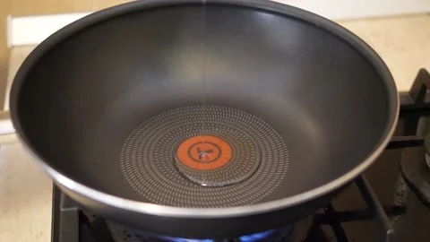 Adding oil into the wok on the stove Stock Footage 169769832